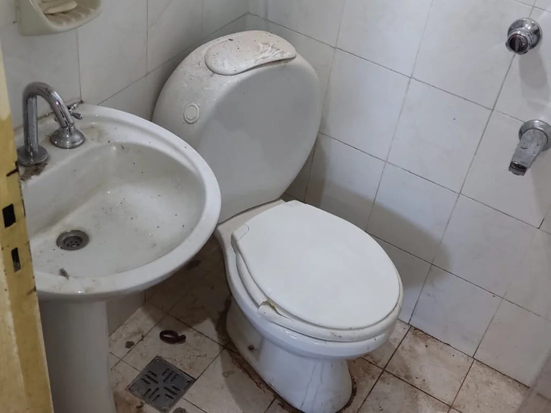 Antes: Baño de un departamento: sarro, restos de obra y juntas tomadas.
