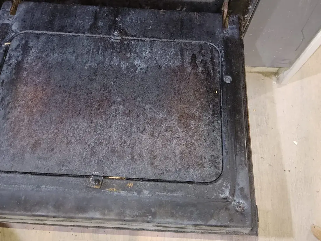 Antes: Puerta de horno con grasa carbonizada. El vidrio vuelve a verse.