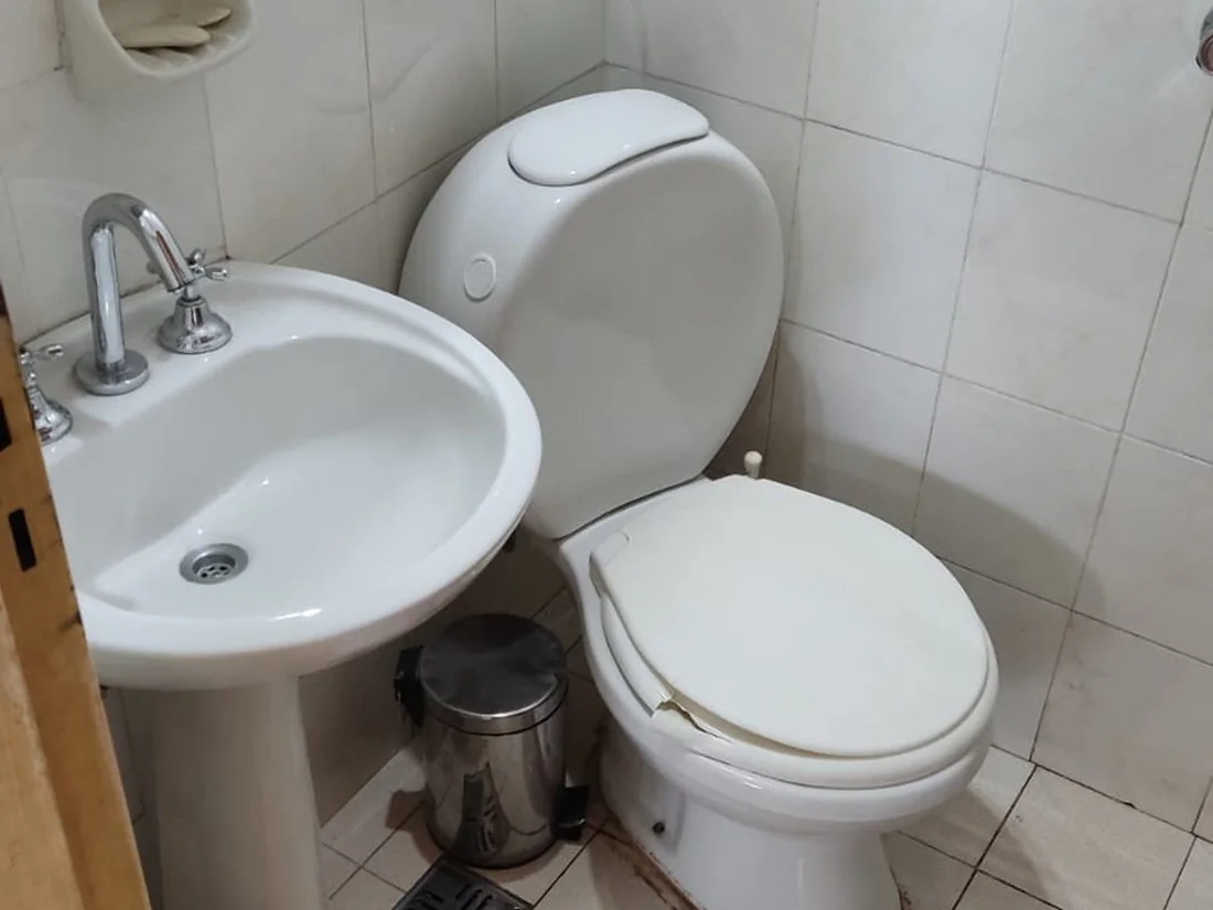 Después: Baño de un departamento: sarro, restos de obra y juntas tomadas.