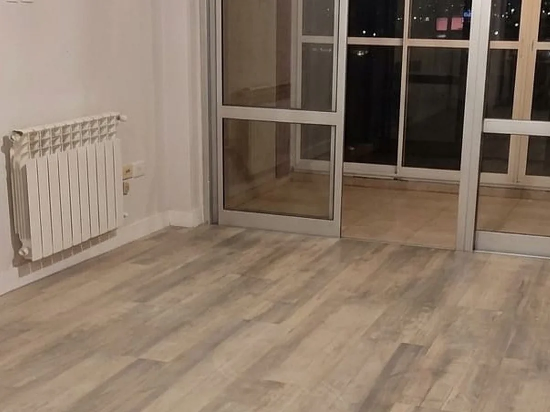 Después: Living de un departamento en Córdoba: polvo fino de obra sobre el piso y en el ventanal.